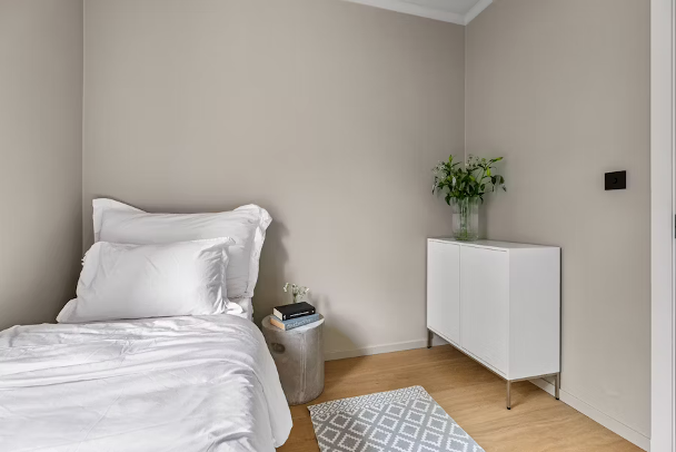 Weißes Bett im minimalistischen Zimmer
