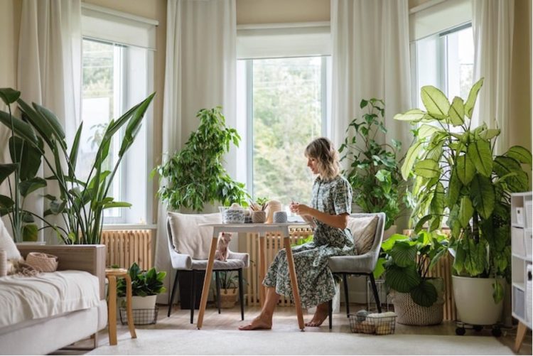 Frau in einem Zimmer mit vielen Pflanzen