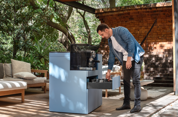 Ein Mann bedient sich an einer mobilen Kaffeemaschine