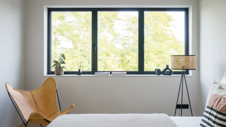 Schwarze Kunststofffenster in einem minimalistisch eingerichteten Zimmer