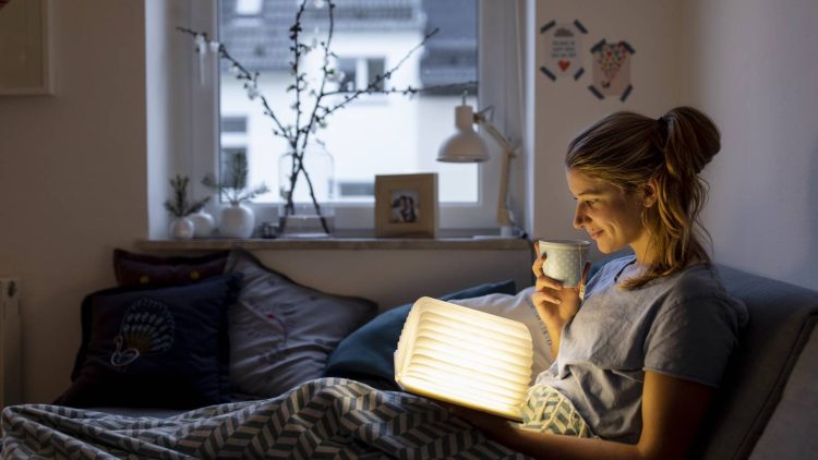 Frau ließt ein Buch und trinkt einen Tee