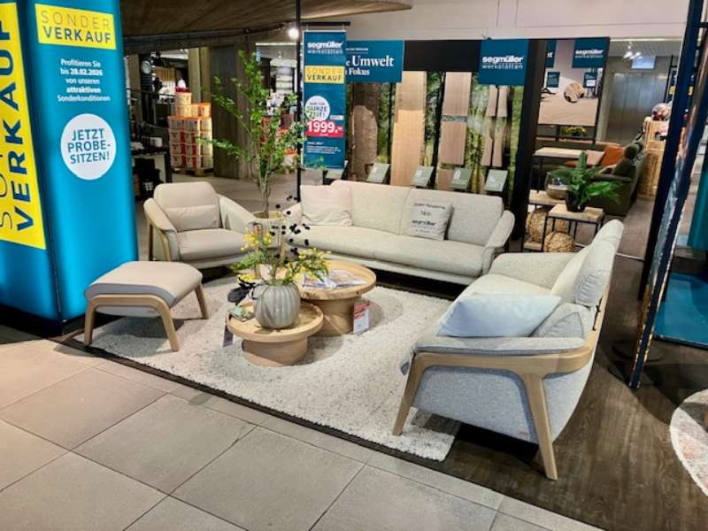 Polstergarnitur in grauem Stoffbezug und sichtbarem Holzgestell